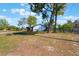 View of the home showcasing the mature trees and spacious front yard at 1510 Chatsworth Ave, Deltona, FL 32738