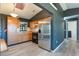 Well-lit kitchen featuring stainless steel refrigerator, wood cabinets, black appliances, and light wood flooring at 1510 Chatsworth Ave, Deltona, FL 32738