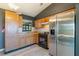 Functional kitchen with stainless steel refrigerator and black oven against dark gray walls and light wood flooring at 1510 Chatsworth Ave, Deltona, FL 32738