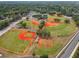Aerial view of well-maintained baseball fields with green grass and red clay, surrounded by lush trees and park amenities at 1514 Pelican St, Longwood, FL 32750