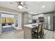 Open kitchen with stainless appliances, gray cabinets, quartz countertop island with seating, and access to a patio at 1514 Pelican St, Longwood, FL 32750