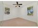 Comfortable bedroom featuring a ceiling fan, neutral carpet, and a pleasant view at 1521 Gants Cir, Kissimmee, FL 34744