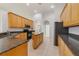 Spacious kitchen featuring wood cabinets, an island, granite counters, and modern appliances at 1521 Gants Cir, Kissimmee, FL 34744