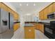 Eat-in kitchen featuring wood cabinets, granite countertops, stainless steel appliances, and an island with breakfast bar at 1521 Gants Cir, Kissimmee, FL 34744