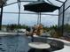 Relaxing pool with a rock waterfall, lush landscaping, and a swim-up table with an umbrella for ultimate enjoyment at 1521 Gants Cir, Kissimmee, FL 34744