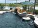Backyard pool area with a waterfall feature, an umbrella and view of the conservation at 1521 Gants Cir, Kissimmee, FL 34744