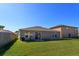 Exterior of the home showing a large yard and sliding glass doors at 15279 Sugargrove Way, Orlando, FL 32828