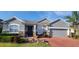 Inviting home exterior showcasing a beautiful brick driveway, manicured landscaping, and stone accents at 1530 Lexington Av Ave, Davenport, FL 33837
