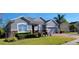 Well-kept single-story home featuring stone accents, a brick driveway, and lush landscaping at 1530 Lexington Av Ave, Davenport, FL 33837