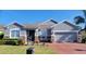 Charming single-story home with a brick driveway, stone accents, and a well-manicured front lawn at 1530 Lexington Av Ave, Davenport, FL 33837