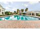Community pool with brick perimeter and clear blue water surrounded by palm trees and lounge chairs at 1530 Lexington Av Ave, Davenport, FL 33837