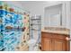 Bathroom featuring a shower with colorful curtain, single vanity with granite countertop, and decorative mirror at 1932 Red Canyon Dr, Kissimmee, FL 34744