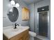 A stylish bathroom features a vanity with a sink, an oval mirror, and a glass-enclosed shower at 2072 Monterey Dr, Deltona, FL 32738