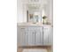 A bathroom with a double sink vanity, white cabinets, gold hardware, and a glass-enclosed shower at 2320 Lelani Cir, Davenport, FL 33897