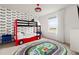 Fun bedroom with racecar themed bunkbeds, racetrack rug, and race flag wallpaper at 2320 Lelani Cir, Davenport, FL 33897