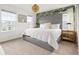 This bedroom features a large bed with a gray headboard, 2 windows, and tropical-themed wallpaper at 2320 Lelani Cir, Davenport, FL 33897