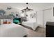 Bright bedroom featuring two twin beds, grey headboards, a stylish side table and a dinosaur-themed wall at 2320 Lelani Cir, Davenport, FL 33897