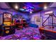 Fun-filled game room features arcade games, custom wall art, and vibrant lighting at 2320 Lelani Cir, Davenport, FL 33897