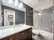 Modern bathroom with a glass-enclosed shower, dark vanity, and stylish mosaic tile accents at 2405 Dellwood Dr, Orlando, FL 32806
