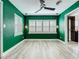 Bedroom with green walls, shuttered windows, and tile floors at 2405 Dellwood Dr, Orlando, FL 32806