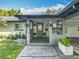Inviting front entrance features a green door, gray brick walkway, and decorative potted plants at 2405 Dellwood Dr, Orlando, FL 32806