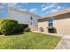 Well-maintained backyard featuring lush green grass, a paved patio area, and manicured hedges at 2731 Cypress Tree Trl, St Cloud, FL 34772