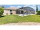 Beautiful backyard with a screened-in pool area, well-maintained lawn, and paved walkway at 2731 Cypress Tree Trl, St Cloud, FL 34772