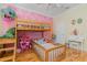 ' bedroom with pink accent wall, bunk beds, hardwood floors, and decorative lighting at 2731 Cypress Tree Trl, St Cloud, FL 34772