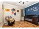 A cozy Bedroom with a crib, glider, and playful wall décor at 2731 Cypress Tree Trl, St Cloud, FL 34772
