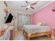 This bedroom is styled with pink walls, a ceiling fan, and a cute bedspread at 2731 Cypress Tree Trl, St Cloud, FL 34772