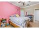 This bedroom has unique decorations, bright pink walls, and a comfortable bed at 2731 Cypress Tree Trl, St Cloud, FL 34772
