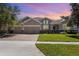 Beautiful home featuring a three-car garage, manicured lawn, brick driveway, and stunning curb appeal at 2731 Cypress Tree Trl, St Cloud, FL 34772