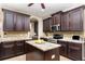 Well-equipped kitchen with dark wood cabinets, stainless steel appliances, granite counters, and kitchen island at 2731 Cypress Tree Trl, St Cloud, FL 34772