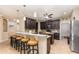 Lovely kitchen with dark wood cabinetry, granite countertop island with bar stool seating, open to the living room at 2731 Cypress Tree Trl, St Cloud, FL 34772