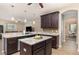 Spacious kitchen featuring an island, granite countertops, dark wood cabinets, and an open layout at 2731 Cypress Tree Trl, St Cloud, FL 34772