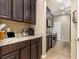 Charming kitchen with dark wood cabinetry, granite countertops, tile backsplash, and stainless steel appliances at 2731 Cypress Tree Trl, St Cloud, FL 34772
