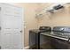 Functional laundry room featuring modern washer and dryer units, with shelving for organization at 2731 Cypress Tree Trl, St Cloud, FL 34772