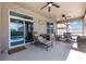 Covered patio featuring ceiling fans, comfortable seating, and views of the pool and backyard at 2731 Cypress Tree Trl, St Cloud, FL 34772