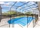 Beautiful in-ground pool enclosed by a screen with a safety fence in a well-landscaped backyard at 2731 Cypress Tree Trl, St Cloud, FL 34772
