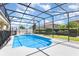Gorgeous in-ground pool is surrounded by a screened enclosure and complemented by lush landscaping at 2731 Cypress Tree Trl, St Cloud, FL 34772