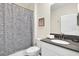 Well-lit bathroom featuring a vanity with dark countertop and patterned shower curtain at 2775 Bookmark Dr, Kissimmee, FL 34746