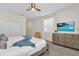 Bright bedroom featuring a ceiling fan, neutral walls, and a TV above a dresser at 2775 Bookmark Dr, Kissimmee, FL 34746