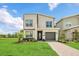 Modern two-story home boasts manicured lawn, complementing the facade, and inviting pathway at 2775 Bookmark Dr, Kissimmee, FL 34746