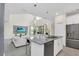 Modern kitchen featuring stainless steel appliances, a center island with seating, and open layout to the living room at 2775 Bookmark Dr, Kissimmee, FL 34746
