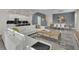 Open-concept living area with a modern kitchen, a large sectional sofa, dining table, and stylish decor at 2775 Bookmark Dr, Kissimmee, FL 34746