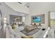 Spacious living room with vaulted ceiling, a large white sectional sofa, modern media center, and adjacent dining area at 2775 Bookmark Dr, Kissimmee, FL 34746