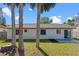 Lush green lawn, palm trees, and outdoor patio offer privacy and space for outdoor activities and entertaining at 2955 Foxcroft Ln, South Daytona, FL 32119