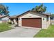 Charming single-story home featuring a brick facade, attached two-car garage, and a well-kept lawn at 2955 Foxcroft Ln, South Daytona, FL 32119