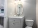 Well-lit bathroom featuring a modern vanity with a round mirror and neutral decor at 2956 Falconhill Dr, Apopka, FL 32712