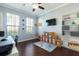 Bright bedroom with dark hardwood floors, shelving, and a large window overlooking the yard at 2956 Falconhill Dr, Apopka, FL 32712
